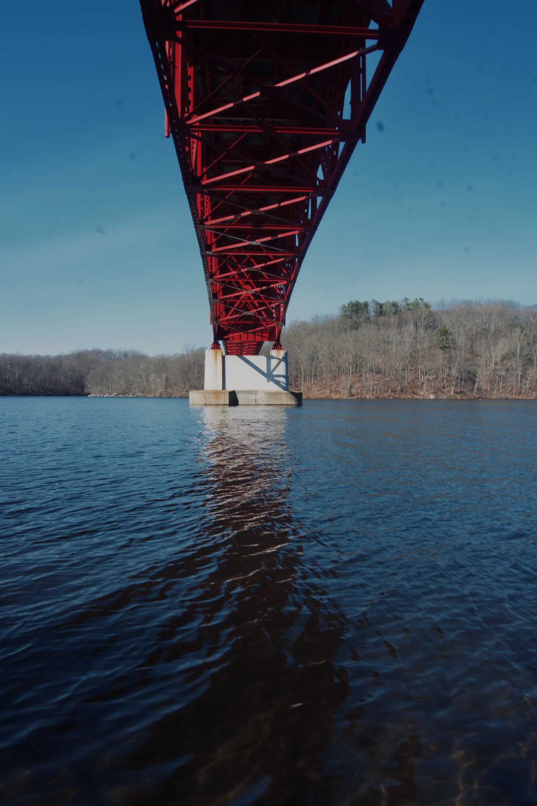 Red bridge stretching across a blue river