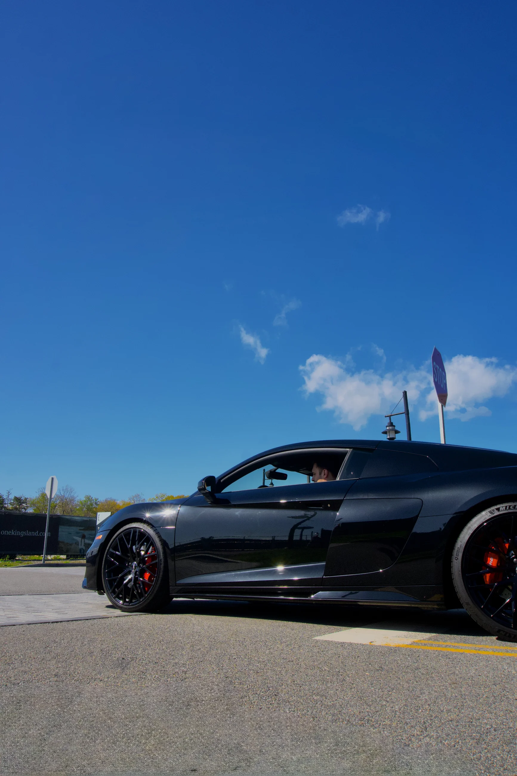 Black sports coupe parked under a vivid blue sky