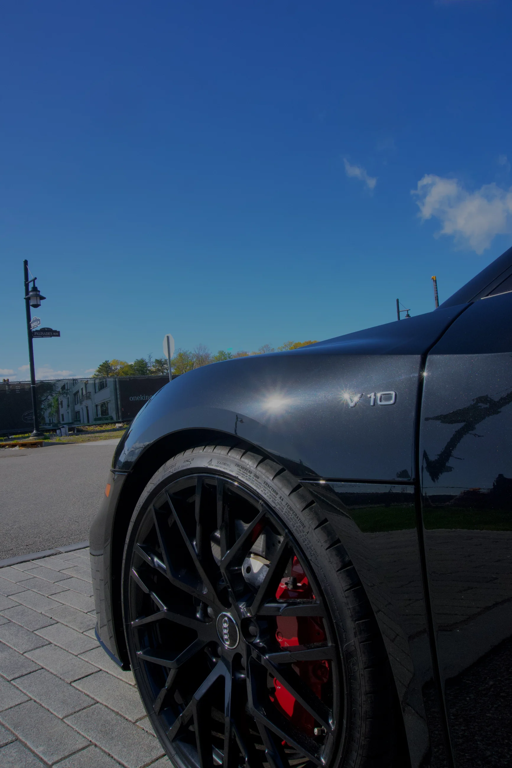 Low-angle view of a black Mustang wheel and front fender